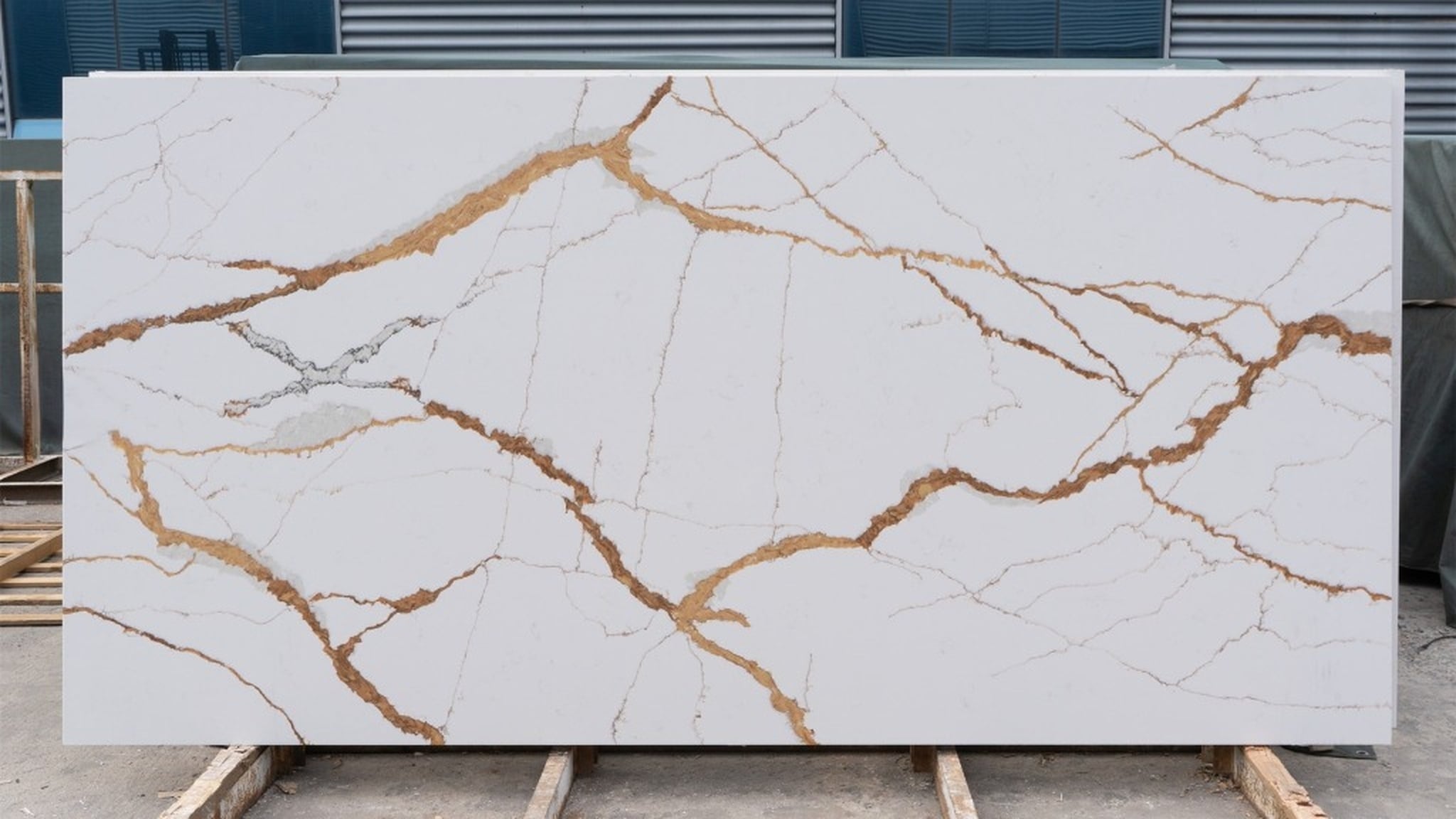 Raw Calacatta gold quartz slab in stone fabrication shop ready for cutting